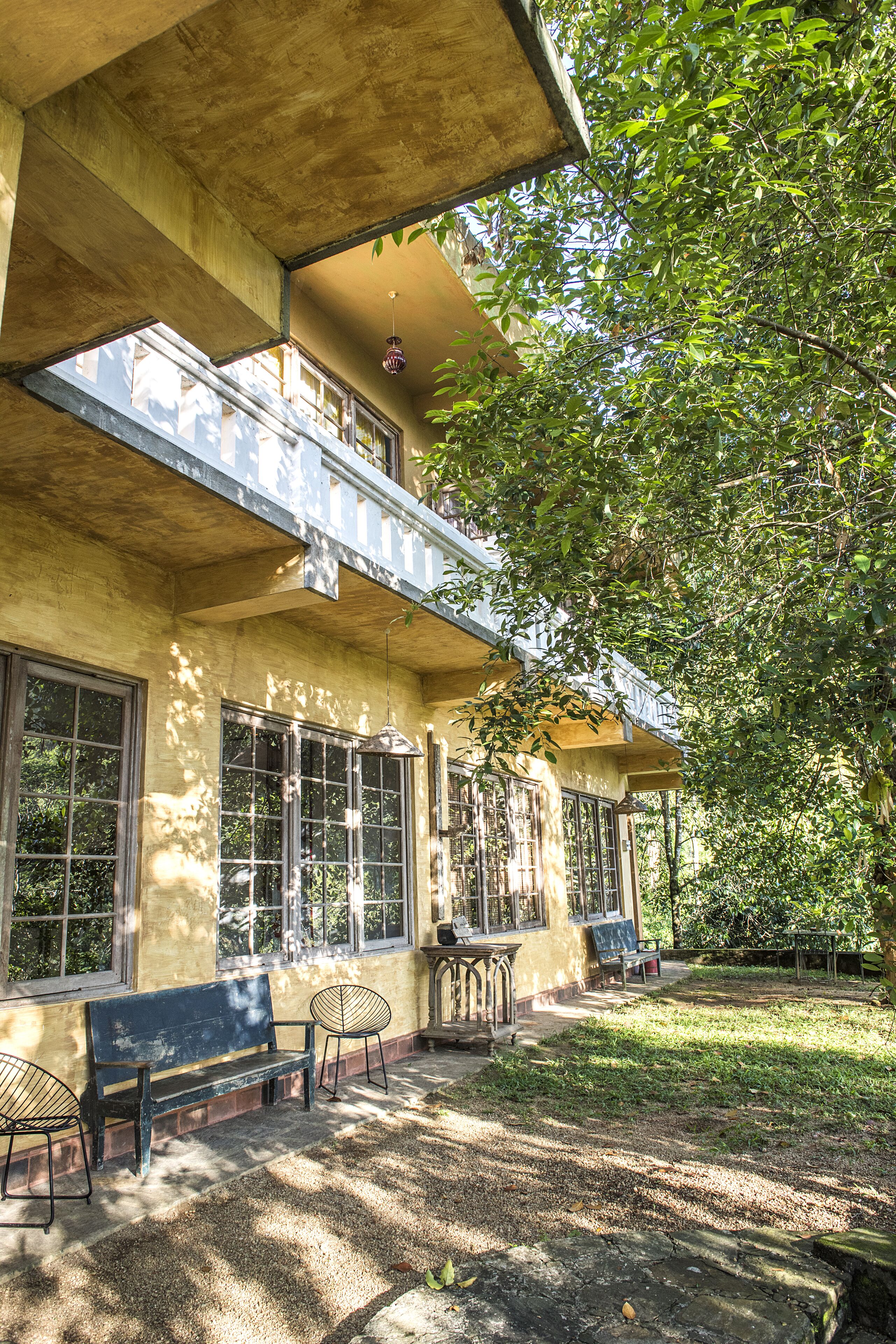 A building with a balcony, large windows, and outdoor seating.