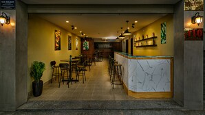 A coffee and pub interior with a bar area, seating, and artwork on the walls. - Dreams Hotel Danang (Da Nang)