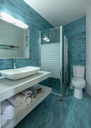 A modern bathroom with a large sink, mirror, and toilet. - Georgia Vicky (Chania)