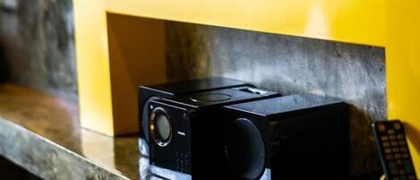 Un televisor montado en la pared con un control remoto sobre el mostrador.