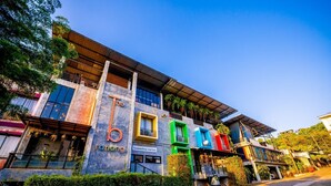 Un edificio moderno con un llamativo letrero de 'bingo', amplias ventanas y una combinación de vegetación y elementos arquitectónicos.