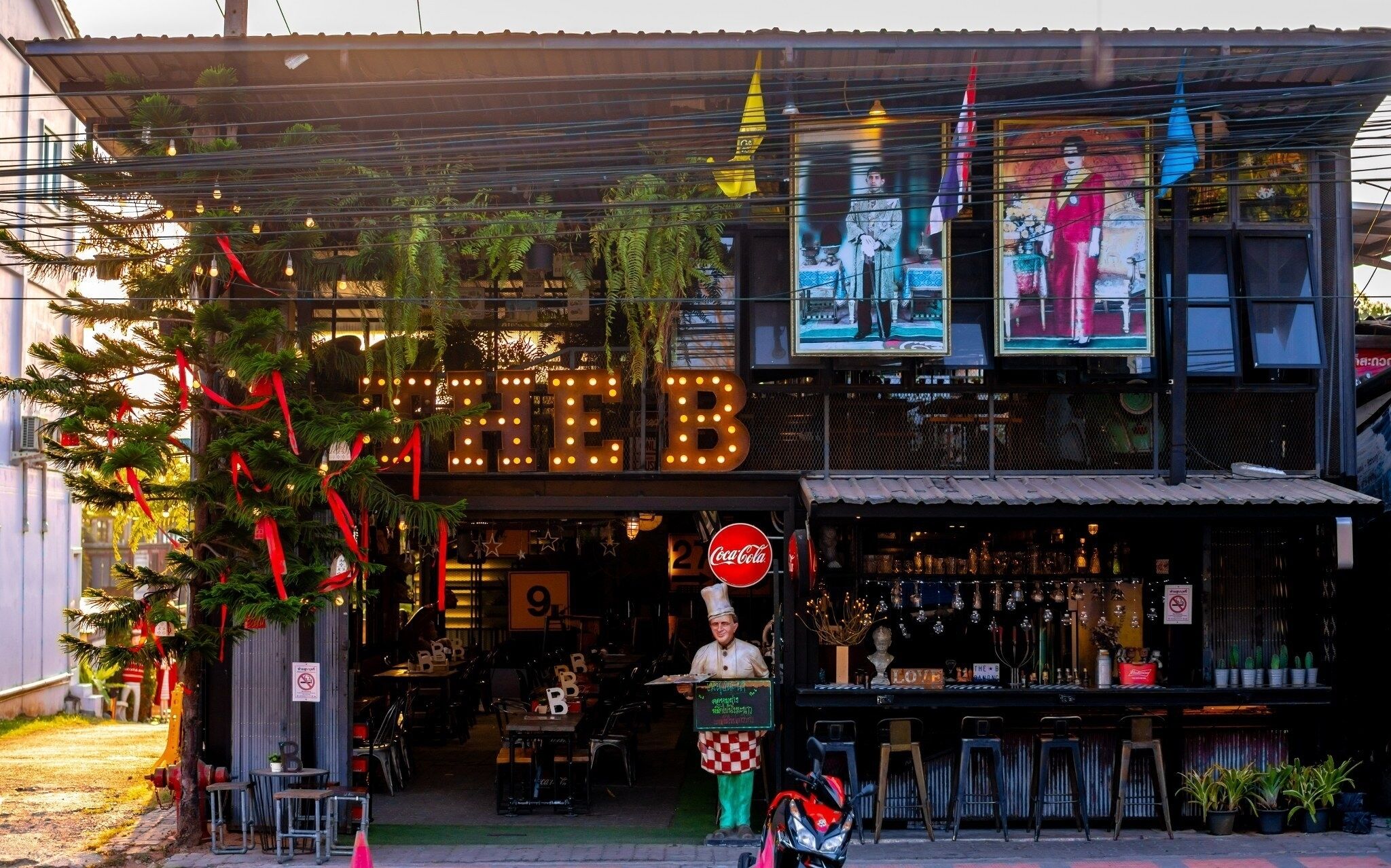 A restaurant with a neon sign, outdoor seating, and a Coca-Cola sign.