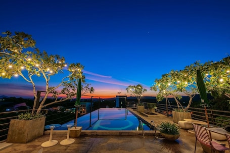 Una piscina al aire libre, sillones reclinables de piscina