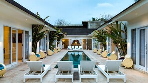 Un espace aménagé au bord de la piscine, avec des chaises longues et une piscine.