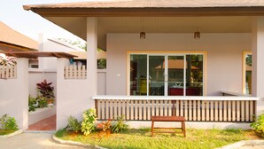 A house with a covered porch, a bench, and potted plants. - Pueanjai Resort and Restuarant (Chumphon)