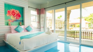 A bedroom with a large bed, a window with curtains, a painting on the wall, and a view of the outside. - Pueanjai Resort and Restuarant (Chumphon)