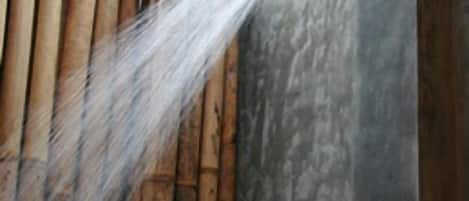 A shower with water spraying down a wall.