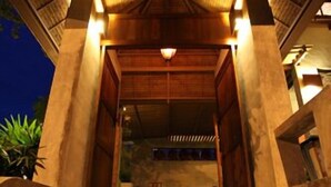A staircase leading to a covered entrance with a wooden ceiling and a light fixture.