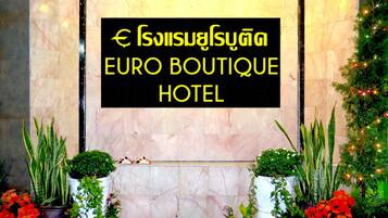 Señal del Euro Boutique Hotel, con pared de mármol y plantas en macetas.