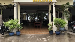Un edificio con un letrero que dice "BUNGALOWS BAR - RESTAURANT HOANG KIM GOLDEN".