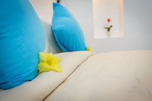 A bed with blue pillows and a yellow flower. - Retreat Home Hoian (Da Nang)