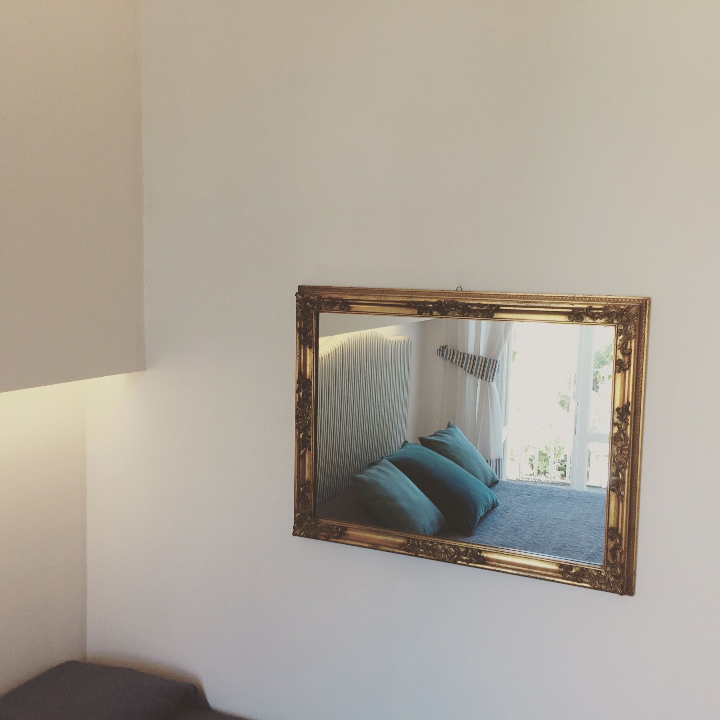 Ein gerahmter Spiegel an der Wand.