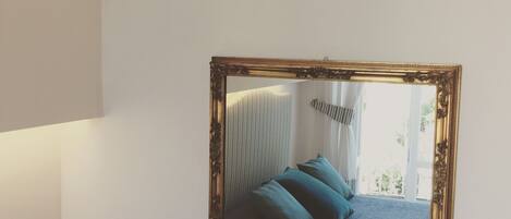 Ein gerahmter Spiegel an der Wand.