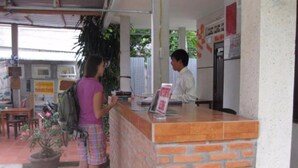 A reception area with a brick counter, a potted plant, and a sign on the wall.