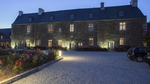 A large stone building with multiple windows and a gravel driveway. - Hôtel de L'Abbaye Le Tronchet - Handwritten Collection (Le Tronchet)
