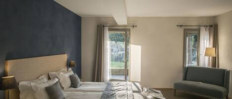 Habitación de hotel con dos camas, un sofá, una mesa y vistas al exterior.
