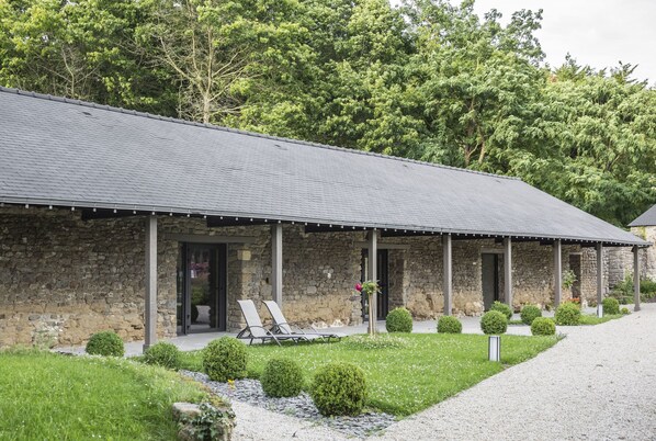 A stone building with a covered porch and outdoor seating.