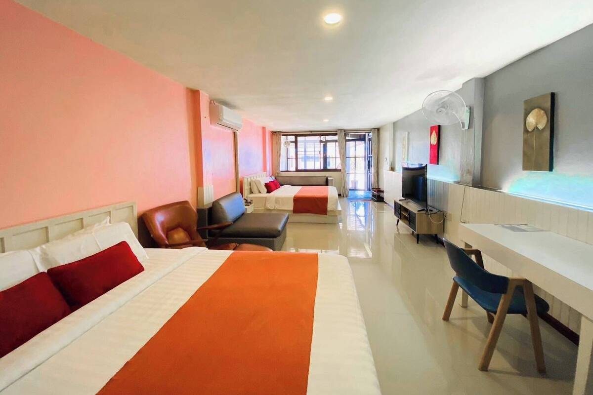 Ein Hotelzimmer mit einem großen Bett, einem Schreibtisch, einem Stuhl und einem Fernseher.