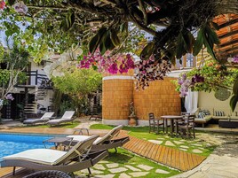 Una piscina al aire libre, sillones reclinables de piscina