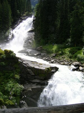 Une cascade d’eau qui dévale des rochers dans une zone boisée.