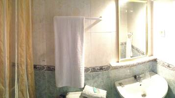 A bathroom with a sink, mirror, and towel rack.