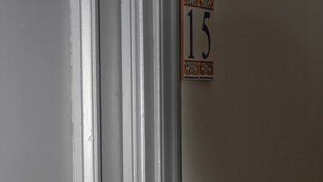 A white door with a small sign on the adjacent wall indicating room number 15.