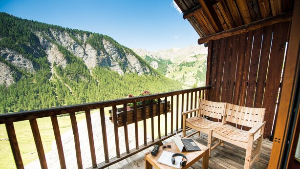 A wooden deck with a wooden bench and a table, overlooking a mountainous landscape. - Les Chalets du Villard (Saint-Veran)