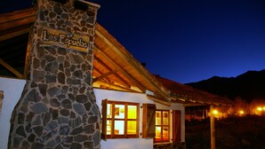 Un bâtiment en pierre avec une enseigne indiquant « Las Espuelas », de nuit.
