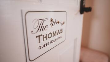 A sign on a door that reads "The Thomas Guest House Inn."