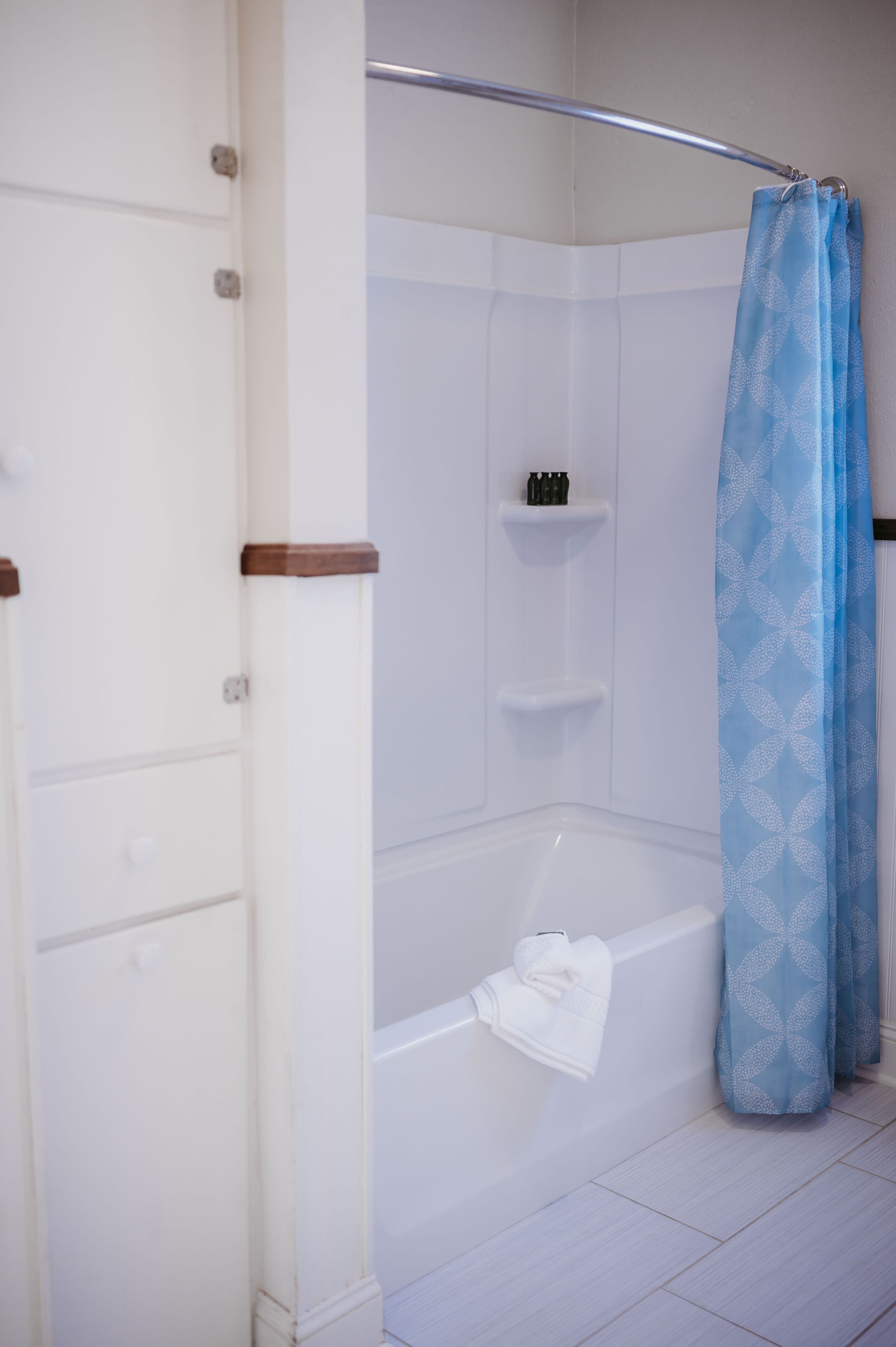 A modern bathroom with a shower, a bathtub, and a towel rack.