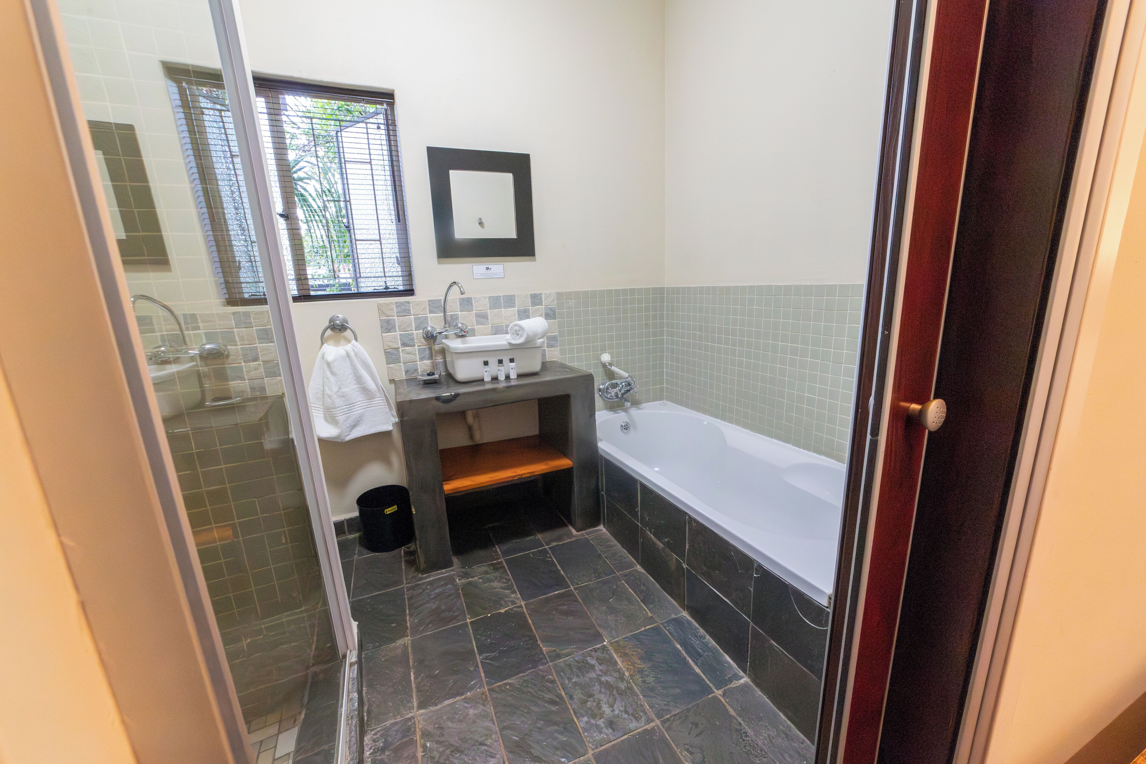A bathroom with a bathtub, a sink, and a window.
