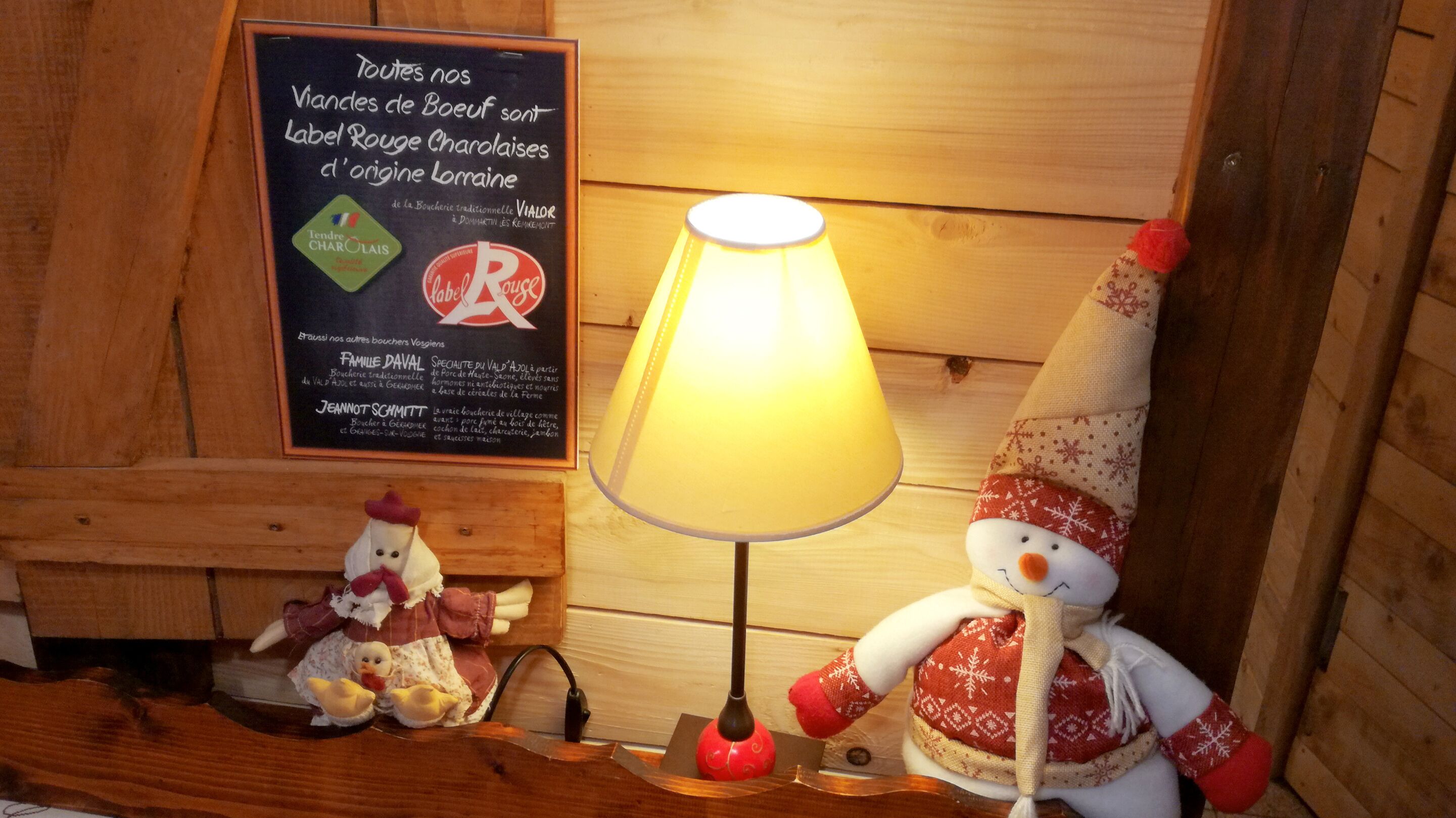 A wooden interior with a signboard, a lamp, and two plush toys.