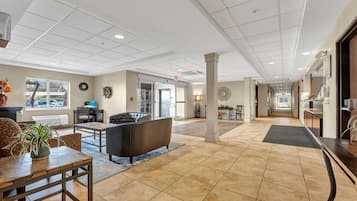 A spacious lobby with a seating area, a reception desk, and a view of the parking lot.