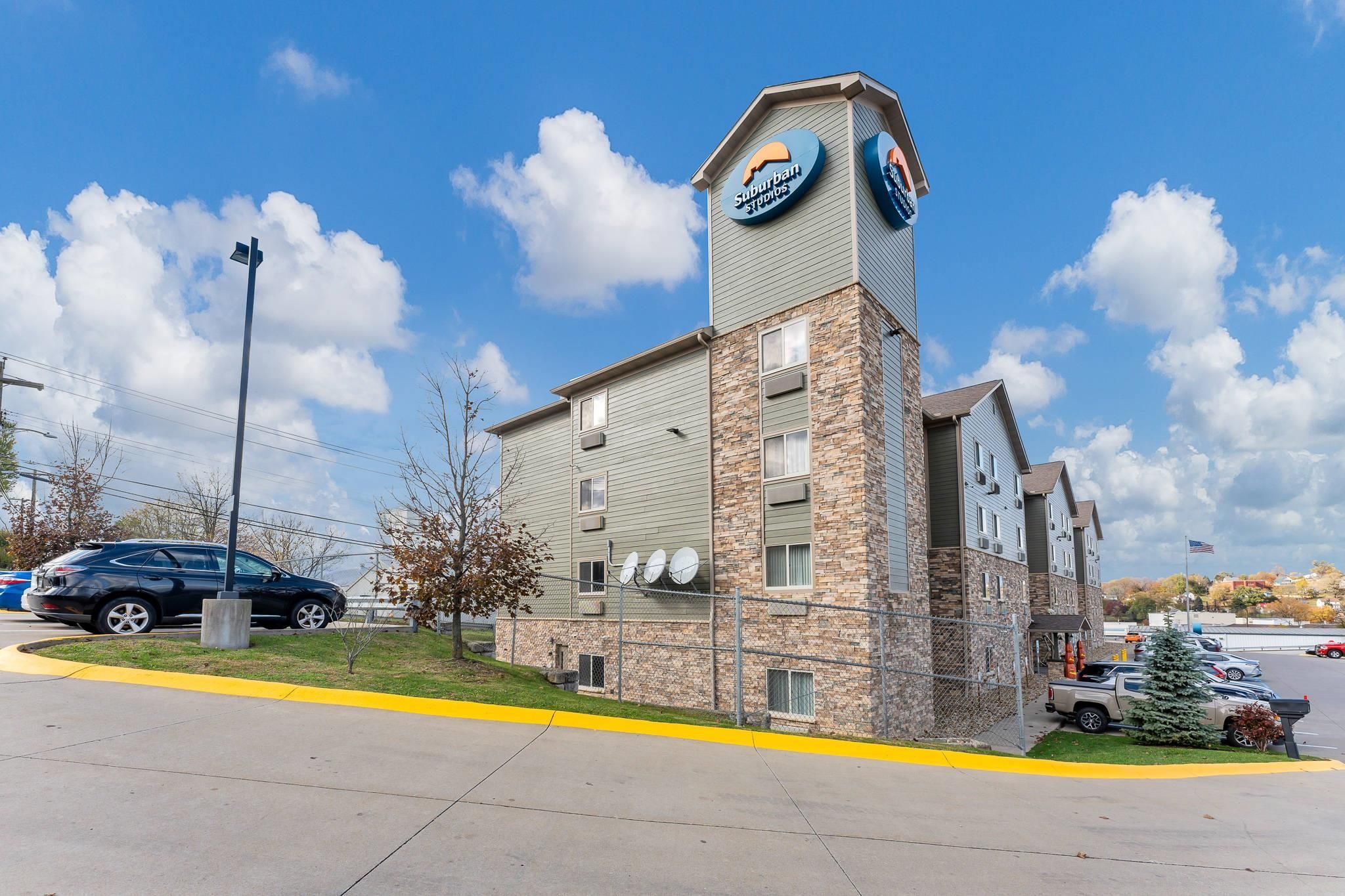 A building with a sign for 'Suburban Studios' and a satellite dish on the roof.