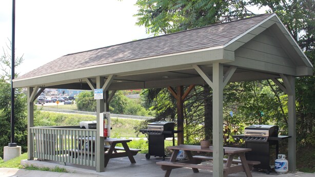 A covered picnic area with picnic tables and a barbecue grill. - Suburban Studios Washington, PA (Washington)