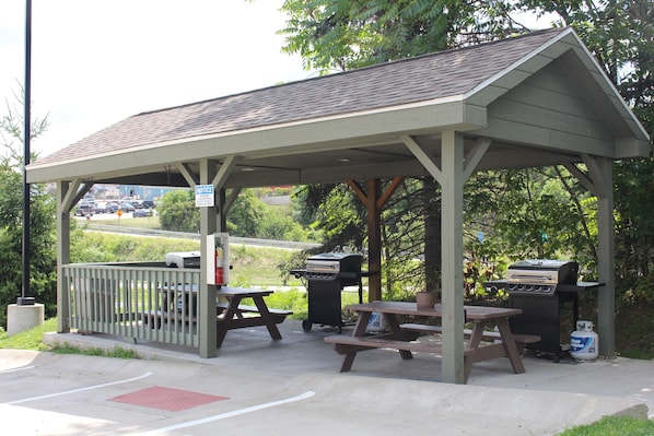 A covered picnic area with picnic tables and a barbecue grill. - Suburban Studios Washington, PA (Washington)