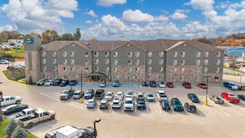 A multi-story hotel with a parking lot full of cars.