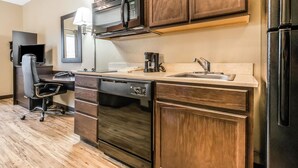 A modern kitchen with wooden cabinets, a microwave, a coffee maker, a dishwasher, and a refrigerator.