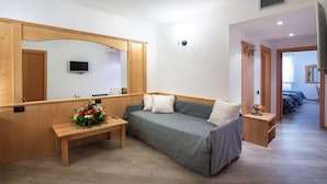 A cozy room with a wooden bench, a sofa, a TV, and a mirror. - Hotel Ristorante Alla Nave (Lavis)
