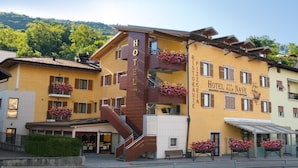 A hotel with a prominent staircase, balconies with flower boxes, and a sign indicating a restaurant. - Hotel Ristorante Alla Nave (Lavis)