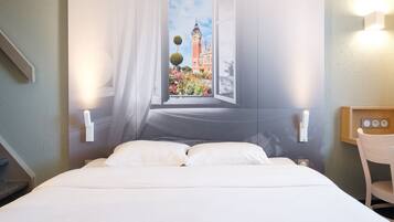 Une chambre d’hôtel avec un lit, une fenêtre donnant sur un célèbre clocher et une table de chevet avec une lampe.