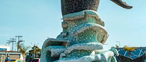 A whale statue with outstretched flippers, set in a fountain with a tiled base.