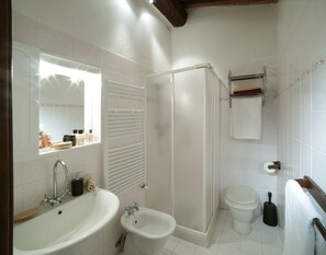 Bathroom features a large sink, bidet, toilet, and glass-enclosed shower.
