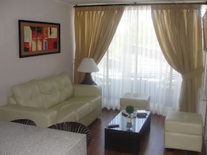 Relax in this inviting living room with a comfortable sofa, armchair, and ottoman arranged around a coffee table.