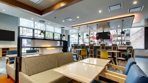 A modern bar area with seating, a bar counter, and a television screen. - Hyatt House Chicago/Evanston (Evanston)