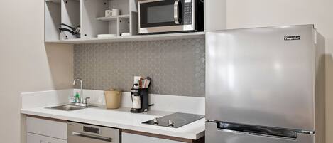 A modern kitchen with a stainless steel refrigerator, microwave, and dishwasher.