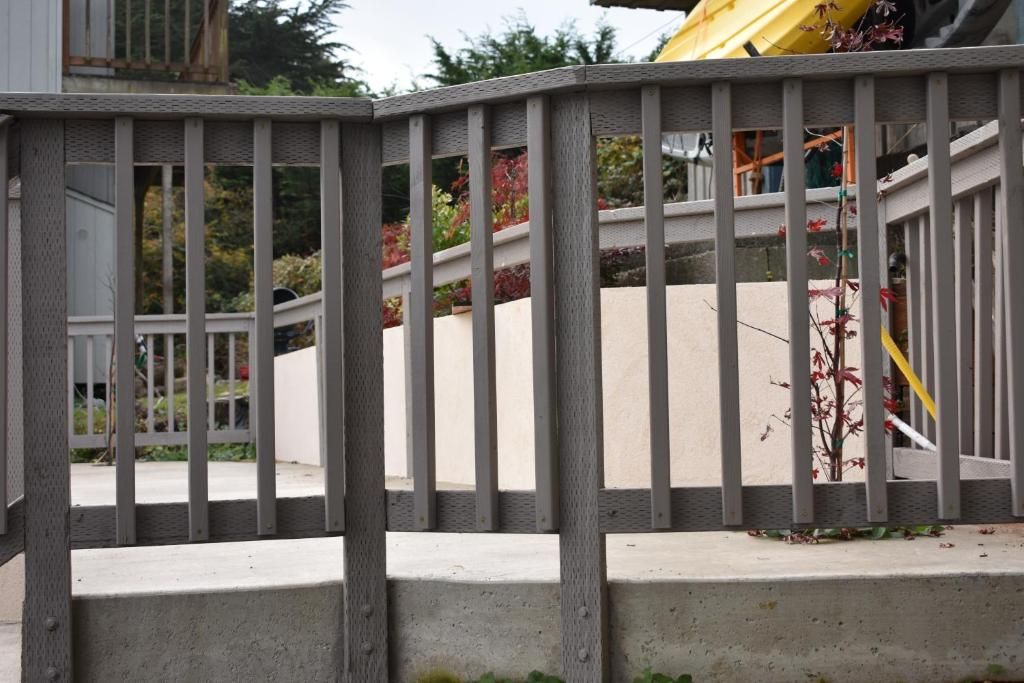 A concrete staircase with a metal railing, leading to a building entrance.