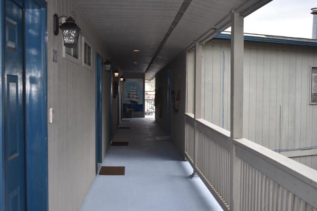 A corridor with doors on the left and a railing on the right.