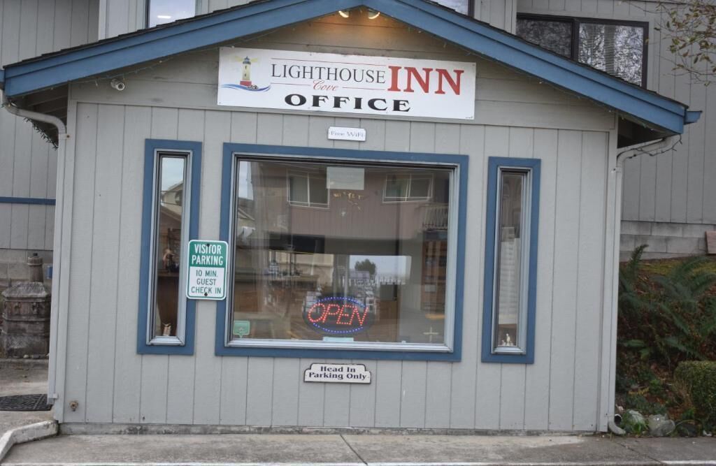 A small building labeled "Lighthouse Inn Office" with a sign indicating "Visitor Parking" and "Head In Parking Only."