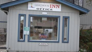 A small building labeled "Lighthouse Inn Office" with a sign indicating "Visitor Parking" and "Head In Parking Only."